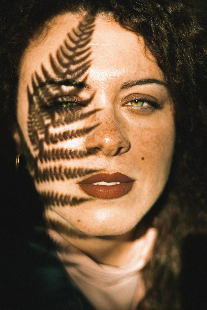 Shadow of leaves falling on young woman face