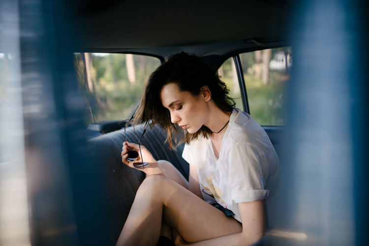 Young woman using mobile phone while sitting in bus
