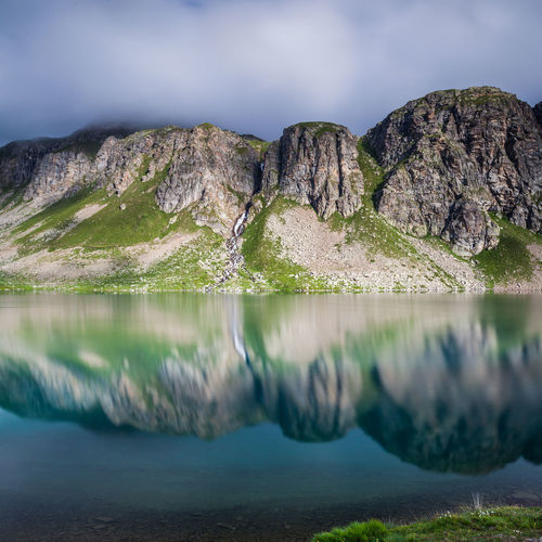 Reflection of mountains against sky on lake at gran paradiso national park