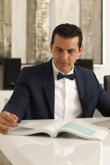 Businessman reading book on table