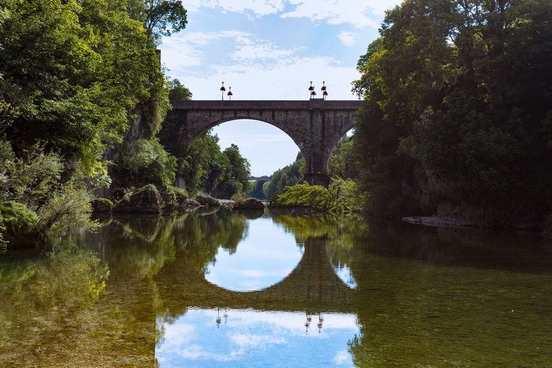 Arch bridge over lake against sky