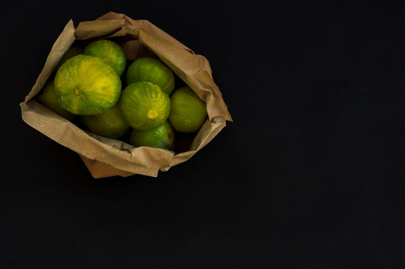 High angle view of fruits in container against black background