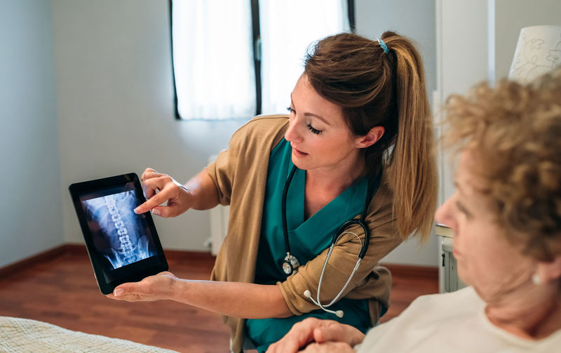 Doctor and patient using digital tablet at hospital