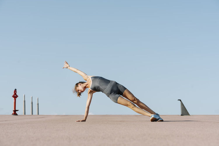 Female sportsperson practicing yoga balancing on one side