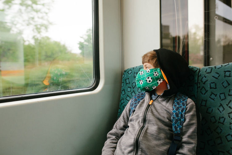 Rear view of woman looking through train window