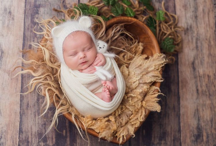 High angle view portrait of cute baby sleeping in basket