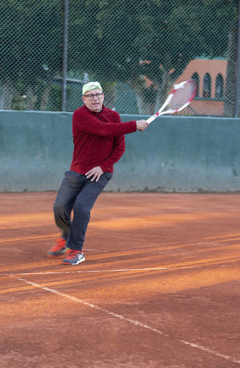 Full length of man playing tennis outdoors