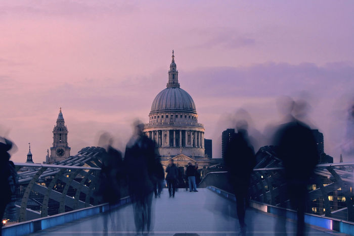 Blurred motion of people on millennium bridge leading towards st paul cathedral at dusk
