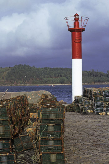 Lighthouse by sea against sky
