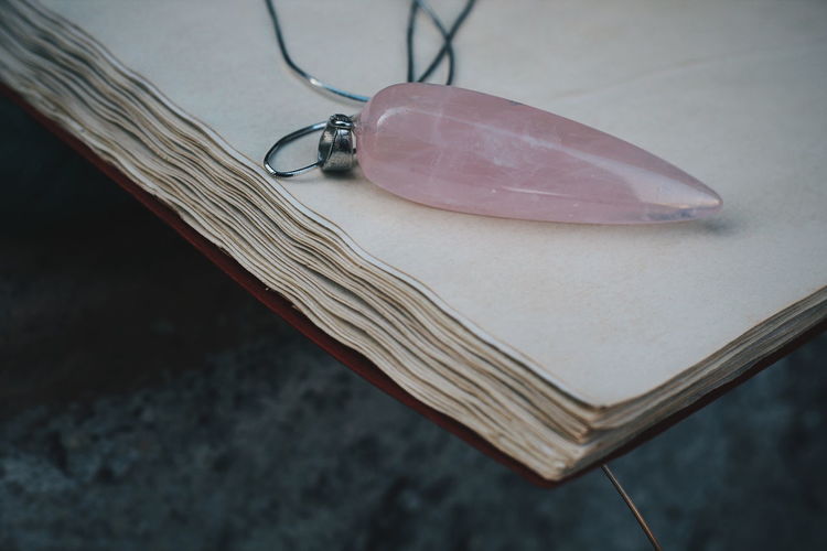 High angle view of pendant over open book on table