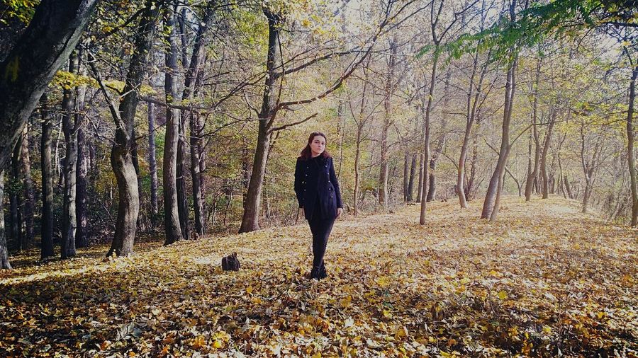 Woman standing at forest during autumn