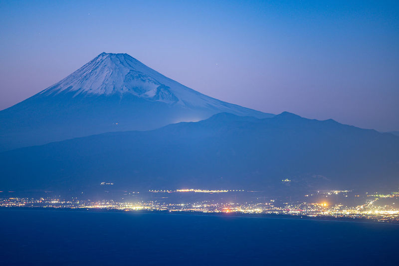 Scenic view of mount fuji, snowcapped mountain against sunset sky