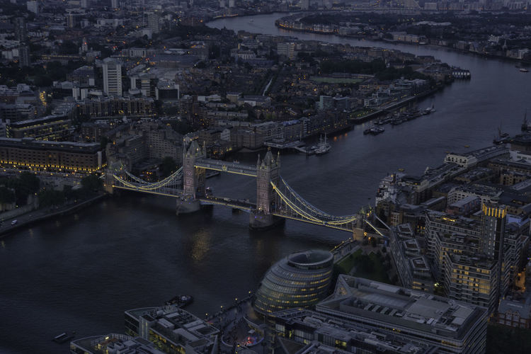 High angle view of illuminated tower bridge over thames river at dusk