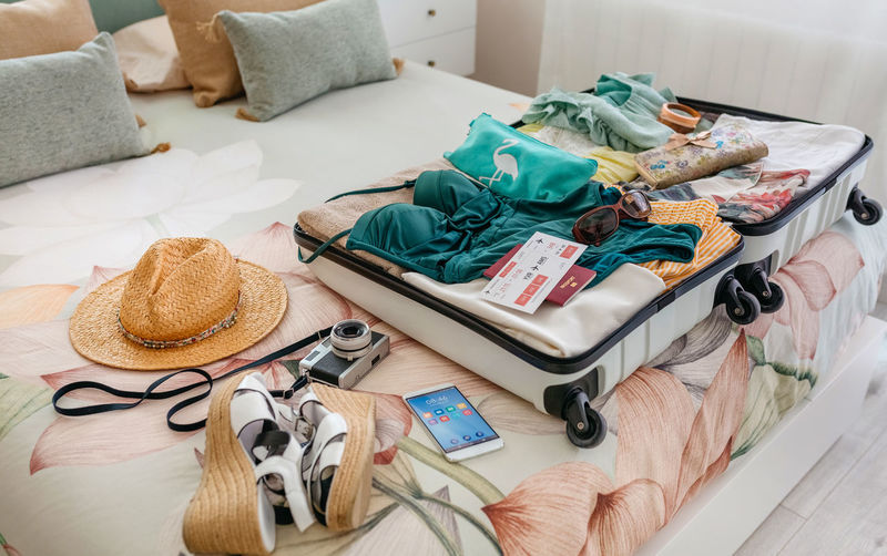 Open woman suitcase prepared for summer vacation