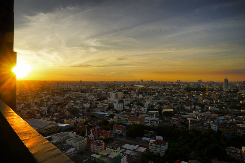 High angle view of city buildings against sky during sunset