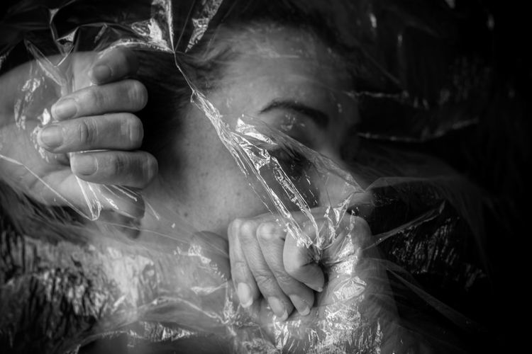 Close-up portrait of young woman holding under plastic 