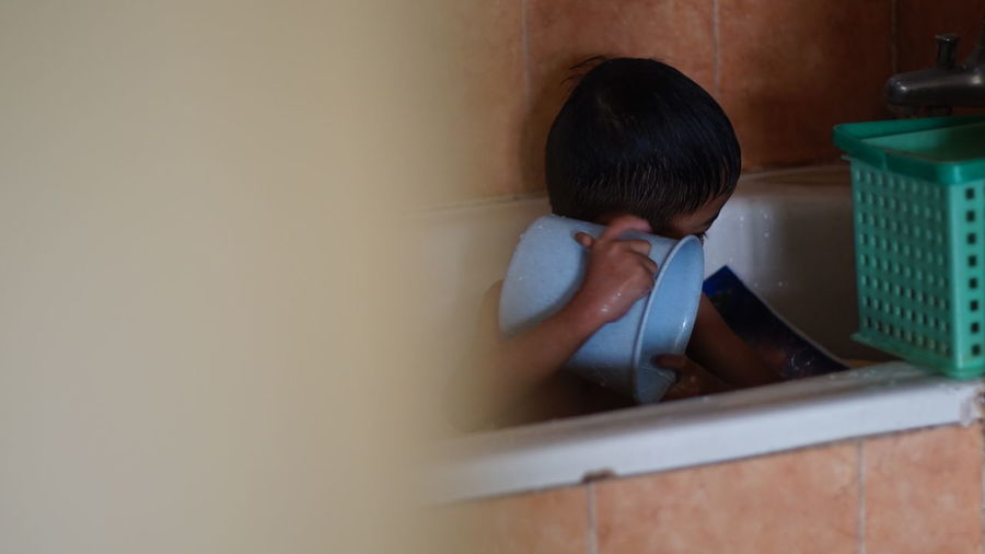 Rear view of boy in bathroom at home