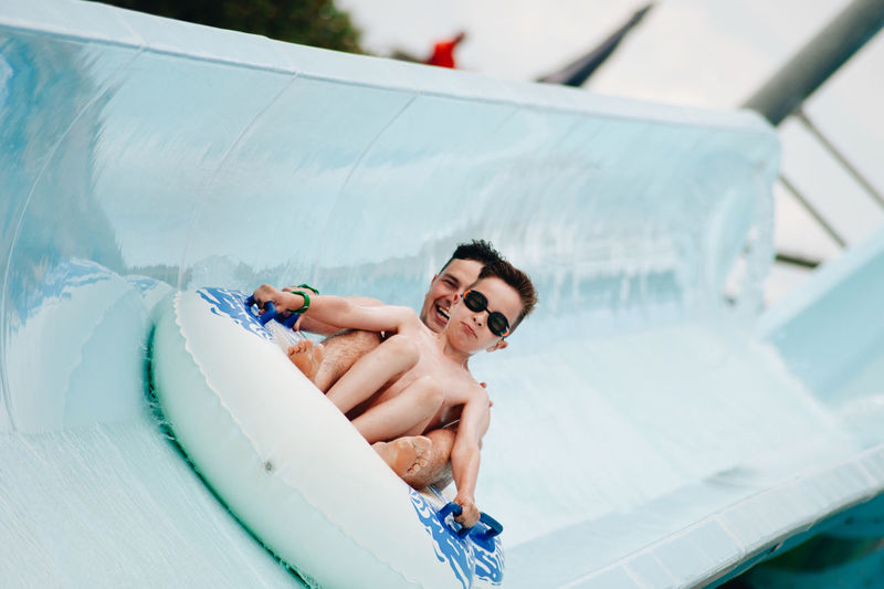 Cheerful father and son enjoying at water park