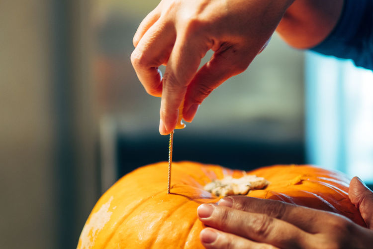 Cropped hand of person making jack o lantern