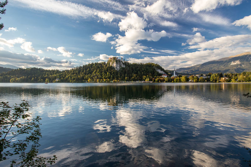 Scenic view of lake bled against cloudy sky