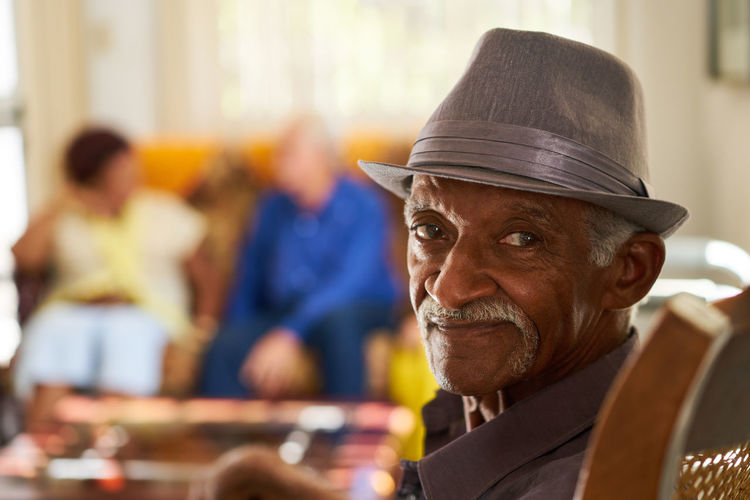 Portrait of senior man wearing hat sitting at home