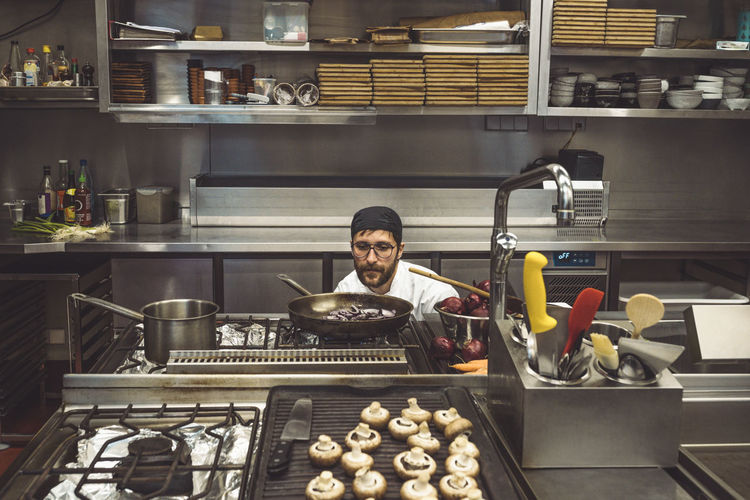 Portrait of a man preparing food in kitchen