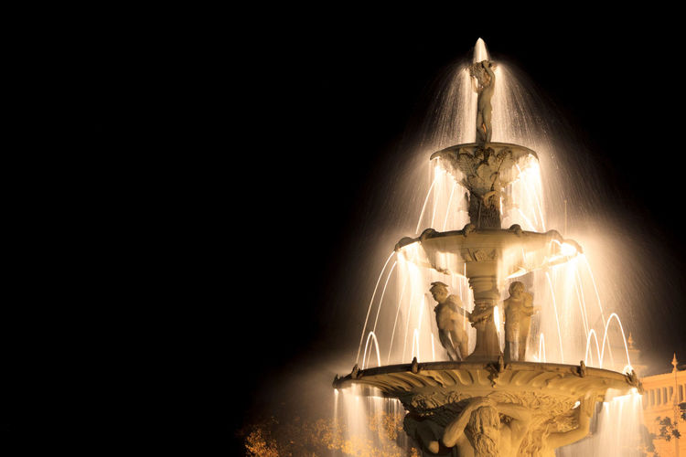 Low angle view of illuminated exhibition fountain at carlton gardens against sky