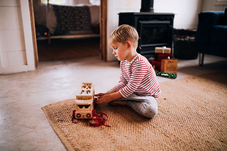 Boy sitting on toy at home