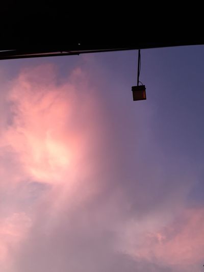 Low angle view of silhouette light against sky at sunset