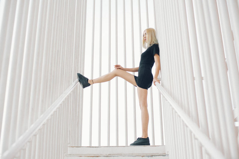 Full length of young woman standing at staircase