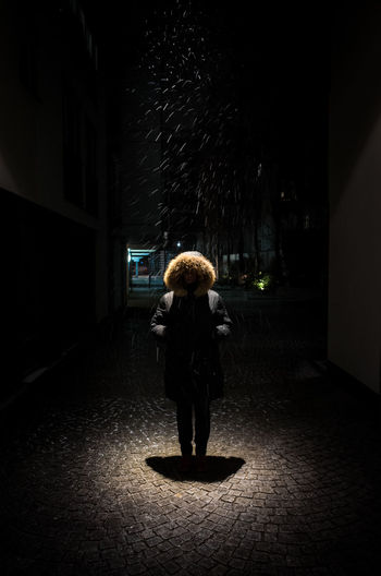 Rear view of girl standing at illuminated night