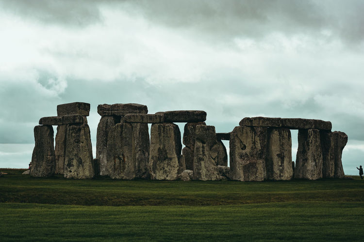 Scenic view of stonehenge monument on the field against sky
