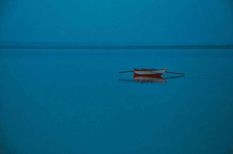 Ship in sea against clear blue sky