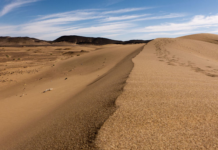 Sand dunes in desert against sky
