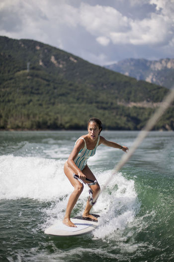 Young woman surfing in the lake