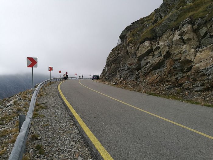 Road leading towards mountain against sky