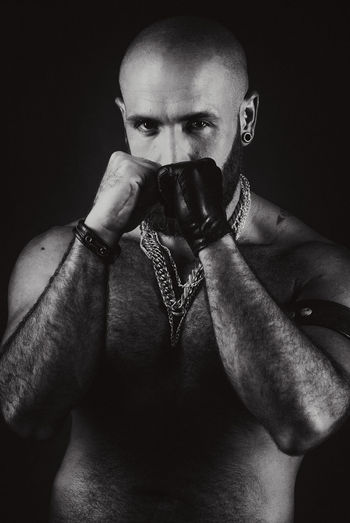 Portrait of young man against black background