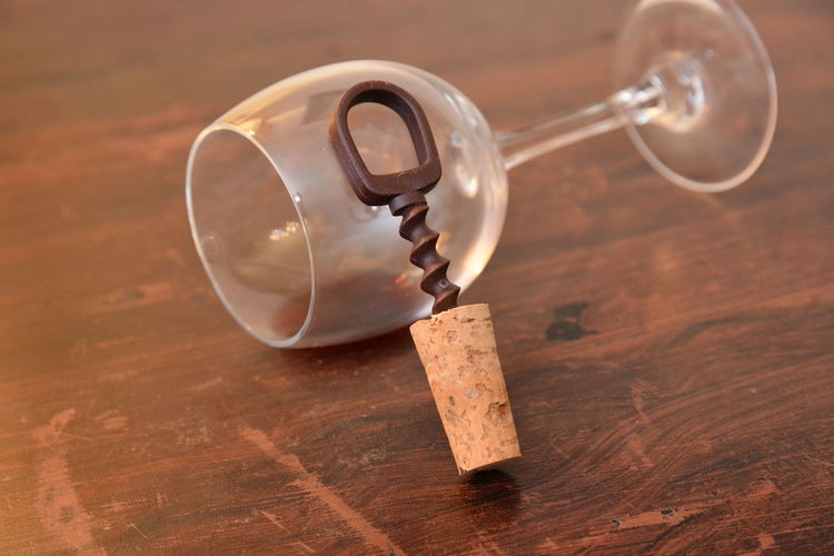 Close-up of wineglass and cork on table
