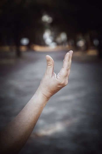 Cropped image of person hand gesturing outdoors