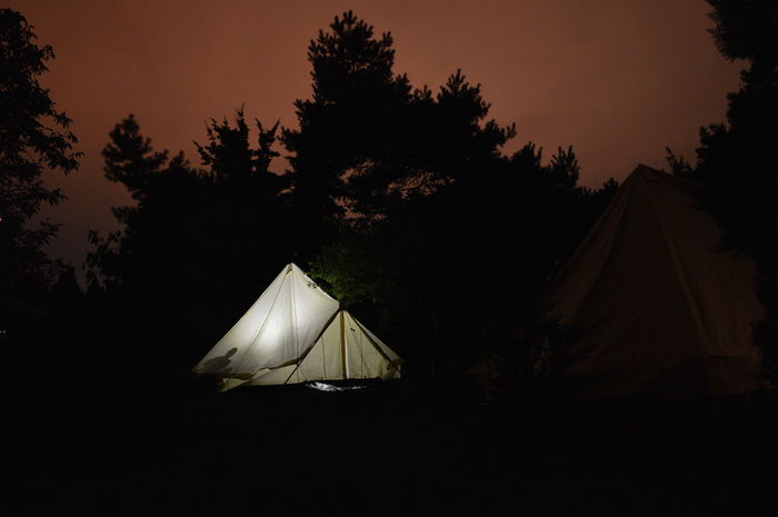 Tent against silhouette trees on landscape