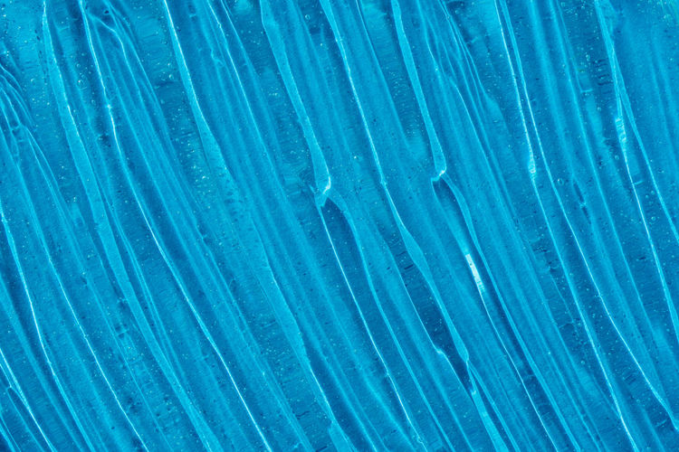 Clear transparent skincare product sample closeup. blue gel texture. 