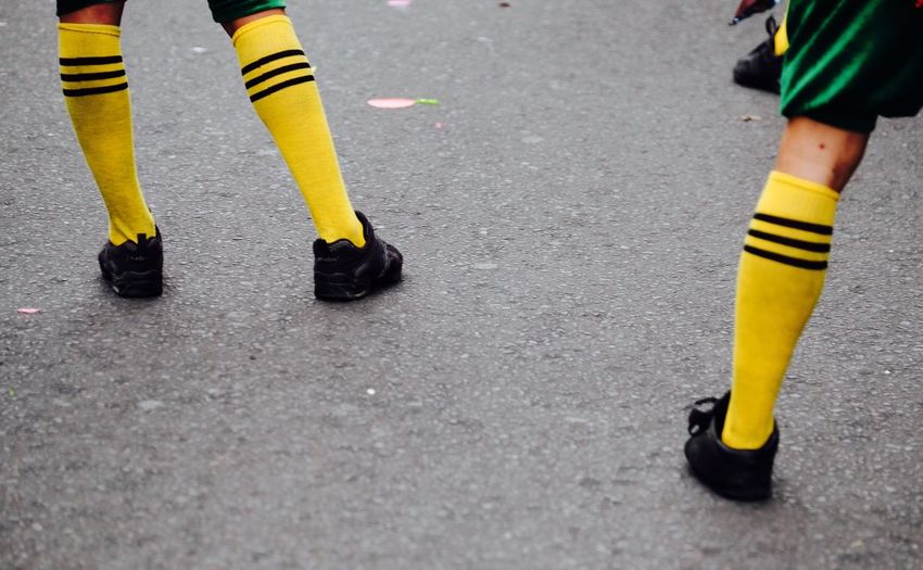 Low section of yellow shoes on road