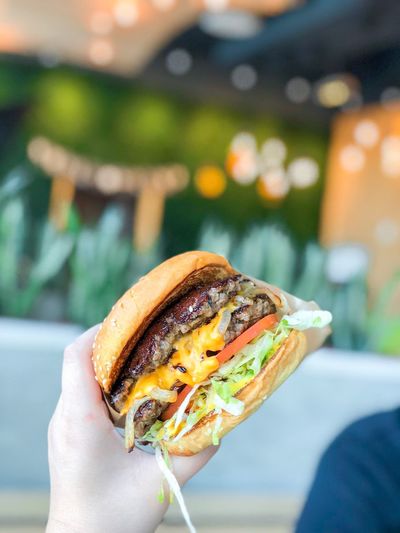Cropped image of person holding burger