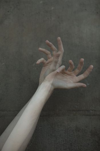 Close-up of human hand against wall