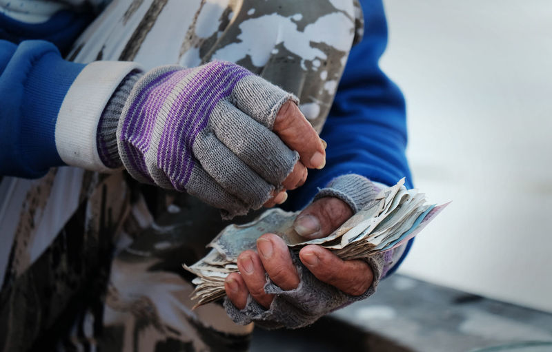 Midsection of man holding paper currency