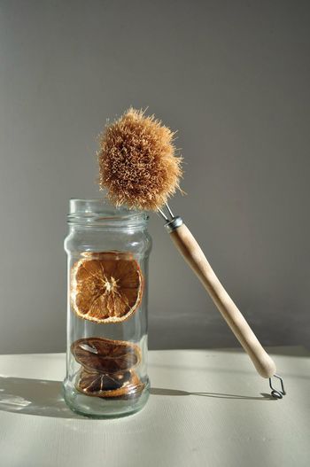 Wooden brush and glass jar against grey background