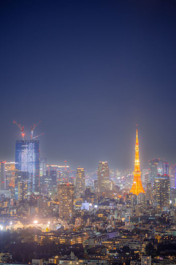 Illuminated buildings against sky at night