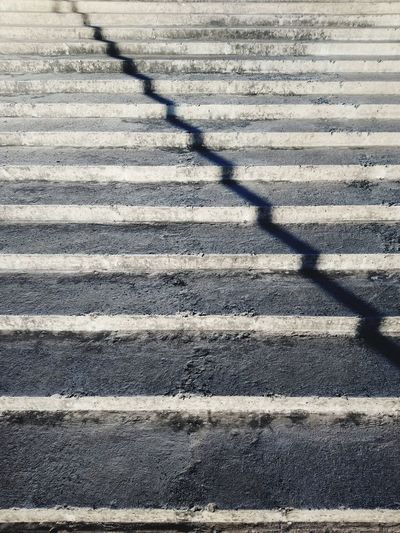 High angle view of shadow of fence on road