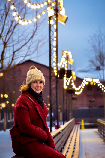 Portrait of smiling woman in city during winter