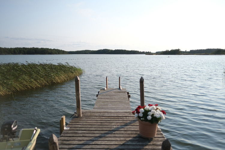 Wooden pier over lake against sky